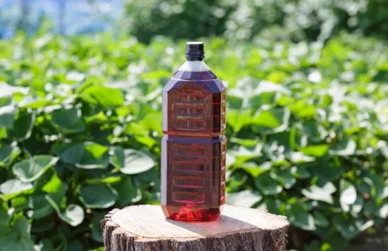 Botella de ácido piroleñoso en un campo de cultivo